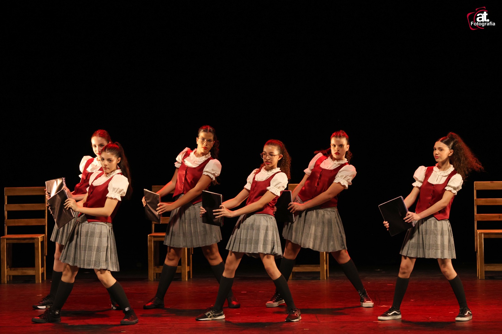 Grupo de alunas em coreografia com figurino colegial